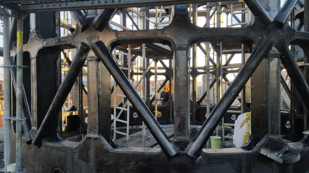 Interior del extremo del trommel FLS con revestimiento de caucho negro terminado, alzadores y aro perimetral cubiertos uniformemente — Kronos Mining