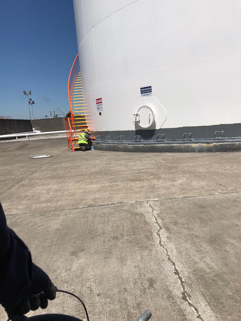 Revestimiento de poliurea en base de silo de almacenamiento Oxiquim Coronel, operario trabajando en junta inferior -- Kronos Mining